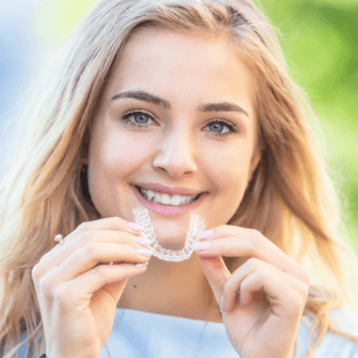 Young woman placing Invisalign clear aligners tray