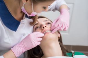 an adult patient with braces chatting with their orthodontist